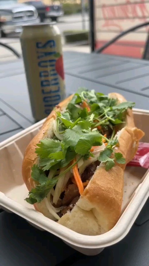 Crispy bánh mì sandwich with fresh cilantro at La Cà Café